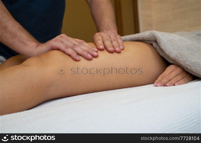 Woman getting legs lymphatic drainage massage in spa salon. Closeup. Body relaxation beauty and body care concept.. Woman getting legs massage in spa salon