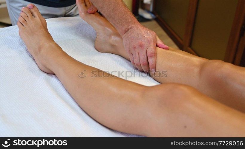 Woman getting legs lymphatic drainage massage in spa salon. Closeup. Body relaxation beauty and body care concept.. Woman getting legs massage in spa salon