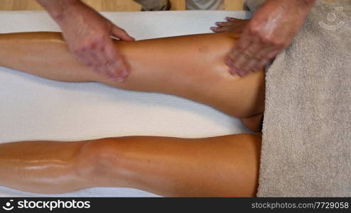 Woman getting legs lymphatic drainage massage in spa salon. Closeup. Body relaxation beauty and body care concept.. Woman getting legs massage in spa salon