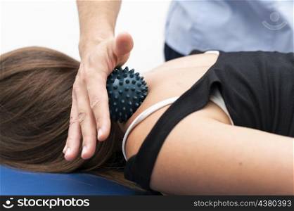 woman getting massage from physiotherapist with ball neck