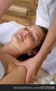 Woman getting neck massage at luxury spa centre