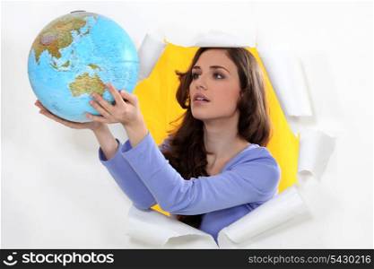 Woman getting out of hole with globe