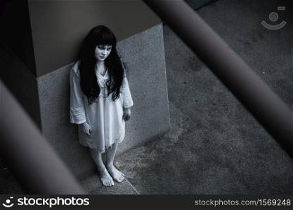 Woman ghost horror standing under building house her looking up, halloween concept