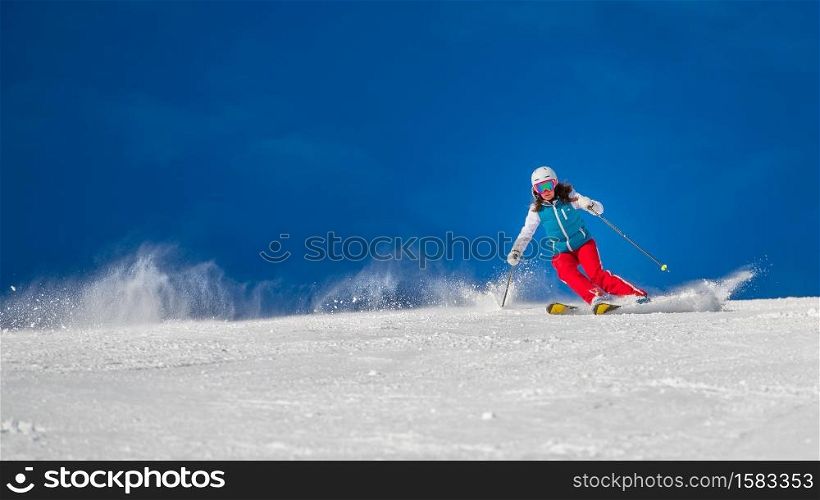 Woman Girl Female Skier skiing downhill during sunny day i