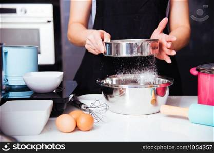 Woman girl in kitchen cooking baker bakery dough with baker sieve