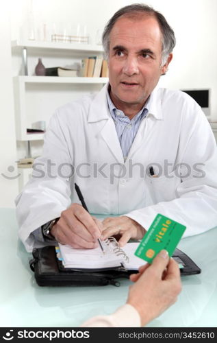 Woman giving a card to a doctor