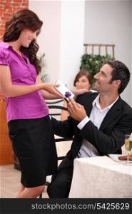 Woman giving a gift over dinner