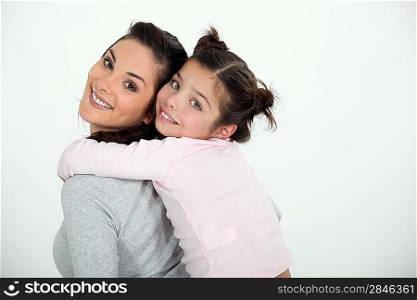 Woman giving her daughter a piggy back ride