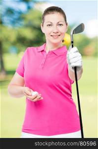 Woman golfer holding a stick and a ball on a background of golf courses