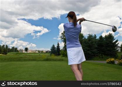 Woman golfer swining a golf club