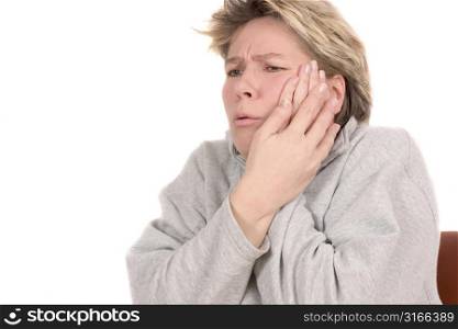 Woman grasping her cheek with painful face