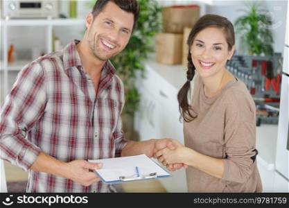 woman grateful handshakes with smiling plumber