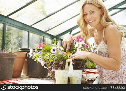 Woman Growing Plants In Greenhouse