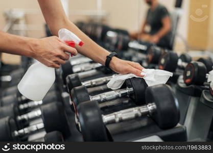 woman gym disinfecting weights before using them. High resolution photo. woman gym disinfecting weights before using them. High quality photo