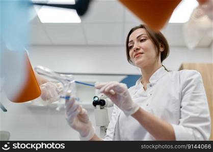 Woman gynecologist taking s&le of biomaterial from patient urogenital tract for PCR examination. Selective focus closeup view on hands. Medical concept. Woman gynecologist taking s&le of biomaterial from patient urogenital tract