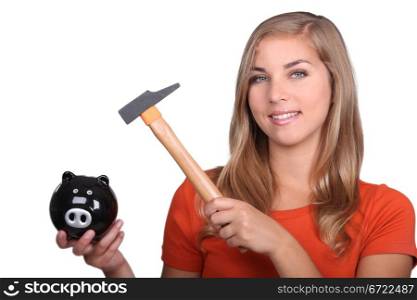 Woman hammering open piggy bank