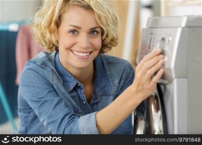 woman hand choosing program for washing machine