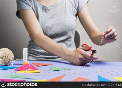 woman hand cutting string with scissor during making bunting