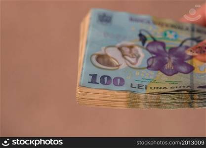 Woman hand giving money like bribe or tips isolated. LEI currency banknotes close up. Reward for hard work, finance and business concept