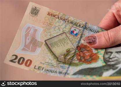 Woman hand giving money like bribe or tips isolated . LEI currency banknotes close up. Reward for hard work, finance and business concept