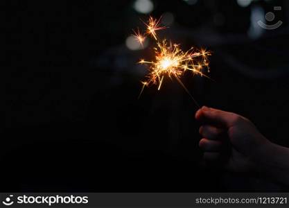 Woman hand holding a burning sparkler