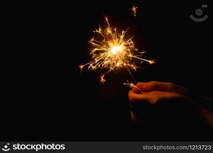 Woman hand holding a burning sparkler