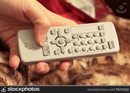 Woman hand holding a grey remote control