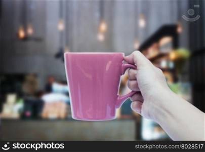 Woman hand holding coffee cup with blurred background, stock photo
