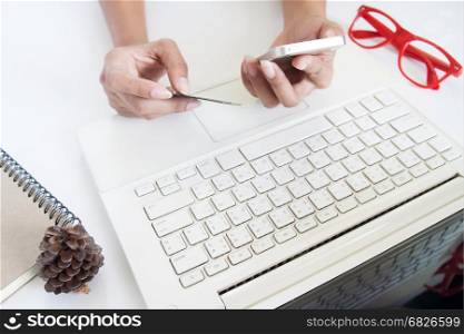 Woman hand holding credit card and using mobile device and laptop, Online shopping concept