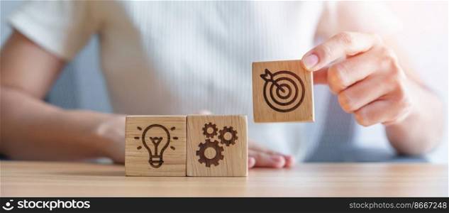 Woman hand holding dartboard above Gear and Lightbulb icon block. business planning process, goal, strategy, target, mission, action, objective, teamwork and idea concept
