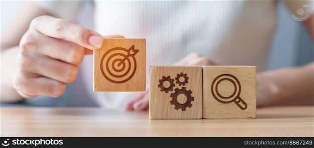 Woman hand holding dartboard, Gear and Lightbulb icon block on table. business planning process, goal, strategy, target, mission, action, objective, teamwork and research concept