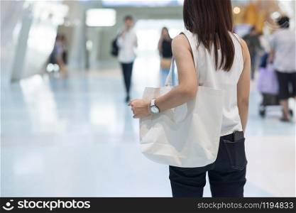 Woman hand holding Eco Shopping bag in store background with Copy space for text. Environmental Protection, Zero waste, Reusable, Say No Plastic, World Environment day and Earth day concept