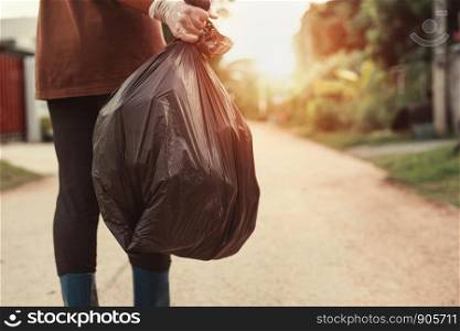 woman hand holding garbage bag for recycle putting in to trash
