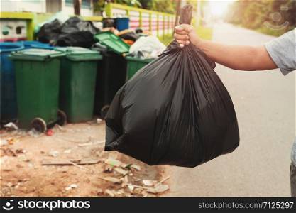 woman hand holding garbage in black bag for cleaning in to trash