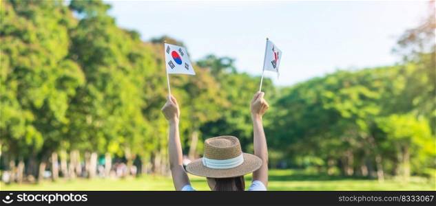 Woman hand holding Korea flag on nature background. National Foundation, Gaecheonjeol, public Nation holiday, National Liberation Day of Korea and happy celebration concepts