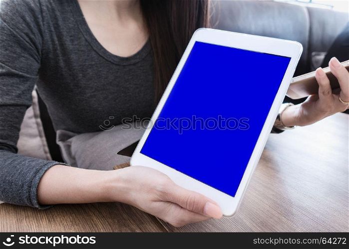 woman hand holding mobile phone tablet with blank screen for advertising text message or promotional content, reading news on cell telephone in coffee place