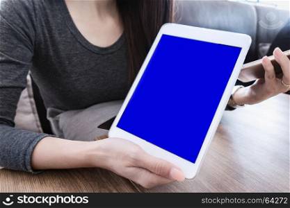 woman hand holding mobile phone tablet with blank screen for advertising text message or promotional content, reading news on cell telephone in coffee place
