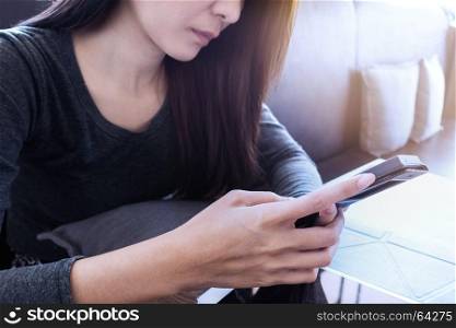 woman hand holding mobile phone with blank screen for advertising text message or promotional content, reading news on cell telephone in coffee place