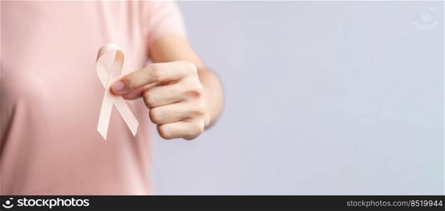 woman hand holding Peach Ribbon for September Uterine Cancer Awareness month. Healthcare and World cancer day concept
