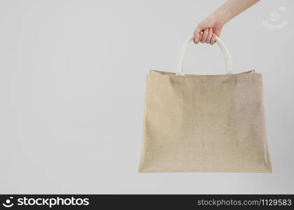 Woman hand holding sackcloth shopping bag with copy space No plastic bag concept