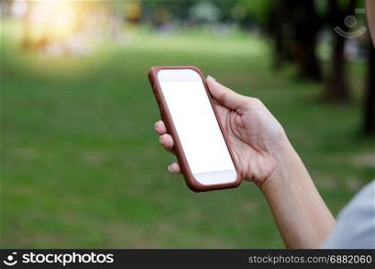 Woman hand holding smartphone on green background