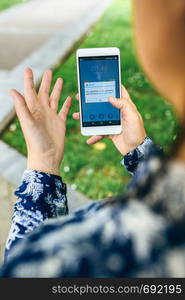 Woman hand holding smartphone with app update error text on the screen. English text in dialog box.