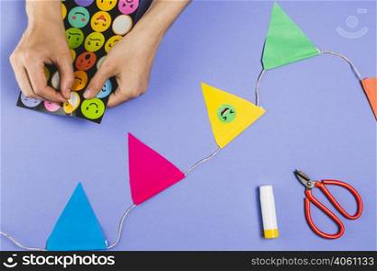 woman hand making bunting with emoji stickers colored background