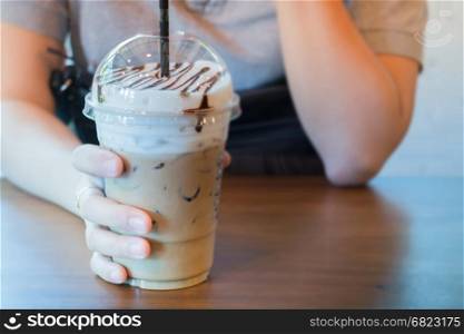 Woman Hand On Iced Milk Coffee Drink, stock photo