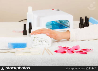 Woman hand on towel, waiting for gel hybrid manicure. Beauty wellness spa treatment concept. Woman hand on towel, next to manicure set