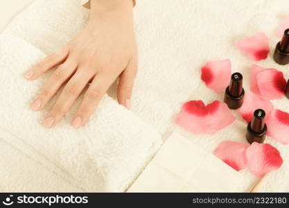 Woman hand on towel, waiting for gel hybrid manicure. Beauty wellness spa treatment concept. Woman hand on towel, next to manicure set