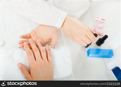 Woman hand on towel, waiting for gel hybrid manicure. Beauty wellness spa treatment concept. Woman hand on towel, next to manicure set