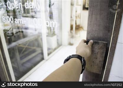 Woman hand opening shop door, stock photo