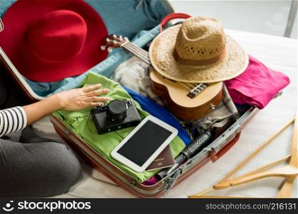 Woman hand packing a luggage for a new journey and travel for a long weekend