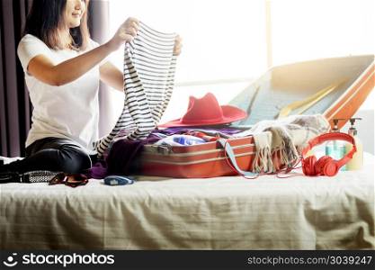 Woman hand packing a luggage for a new journey and travel for a long weekend . Woman hand packing a luggage for a new journey and travel for a